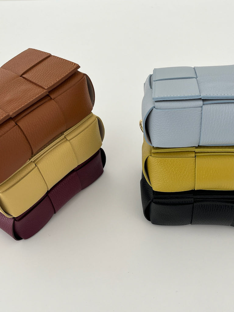 6 colourful leather bags stacked on top of each other